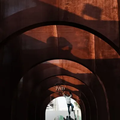The magic begins long before the guests arrive. Here, our team is hard at work constructing the arched tunnel for a 'Midsummer Night's Dream' Sangeet, with the sun casting dramatic shadows.