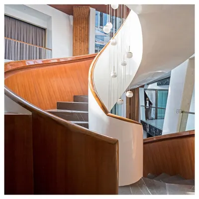 The sculptural staircase of the Cleft House is more than a means of circulation; it's a centerpiece that connects the family across different floors. The flowing form, crafted from wood and white plaster, contrasts with the dark marble and raw concrete textures of the home.