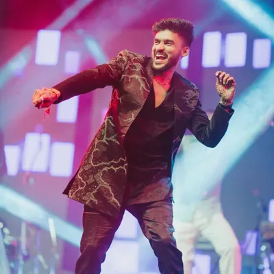 The energy of a live performance at a Sangeet night. This shot captures the groom's brother setting the stage on fire, a perfect example of a "shaam shaandaar."