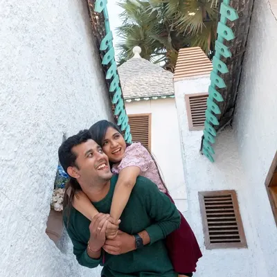 A moment of pure joy and playfulness. He gives her a piggyback ride through a charming, narrow alleyway, and their laughter is infectious. This is what happy, carefree love looks like.