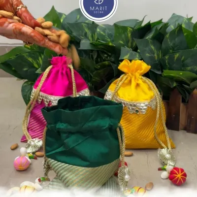 Celebrate love, share sweetness, and gift a potli of joy. Here, a hand filled with almonds pours them into one of my vibrant handcrafted potlis, ready to be gifted.