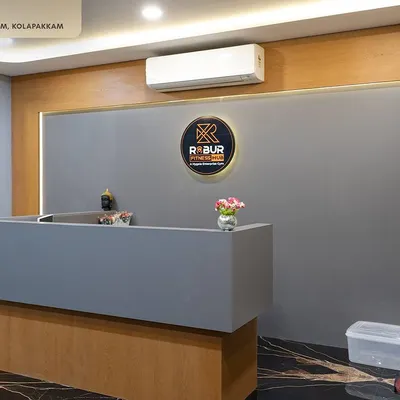 The first impression matters. The reception at Robur Fitness Hub features a sleek, minimalist desk, wood-paneled back wall, and the gym's logo, setting a professional and modern tone the moment members walk in.