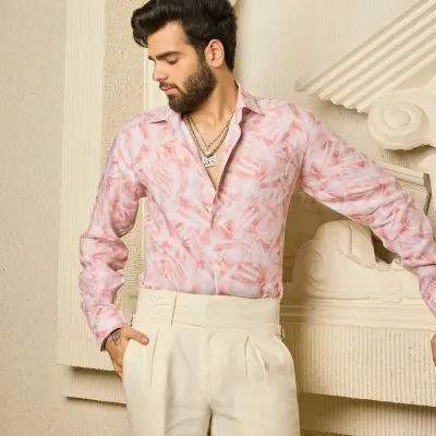 Breezy shades and timeless charm. This light pink linen shirt features a soft, abstract leaf-like pattern and is paired with cream pleated trousers for an effortlessly elegant summer look.