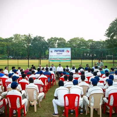 Young cricketers in their whites listen attentively during the prize distribution ceremony of the U-16 Payyade Trophy. This event marks a significant milestone for these budding Mumbai cricket stars.