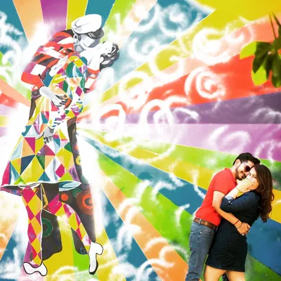 A fun and energetic couple shoot against a vibrant graffiti wall. This kind of environmental portraiture allows couples to express their personality, and the bright colors create a dynamic and modern love story.