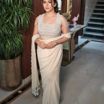 Elegance in every detail. This look redefines minimal with a touch of class and quiet luxury, featuring clean makeup and a chic hairstyle to complement a modern designer saree.