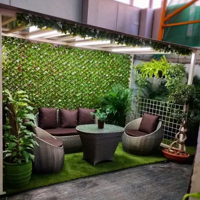 Our garden centre is designed to be an oasis. This seating area, complete with comfortable garden furniture and surrounded by artificial green walls, shows how you can create a serene outdoor living space.