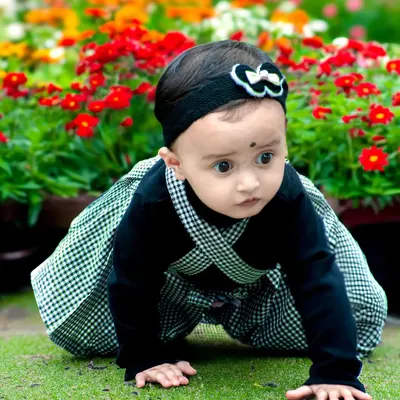 A curious toddler exploring a garden full of colorful flowers. This candid baby photoshoot captures the wonder of discovery in a natural, outdoor setting.