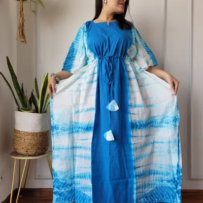 A beautiful tie-dye cotton kaftan in shades of blue and white. This piece features a central panel design and an adjustable drawstring waist for a comfortable, flattering fit.