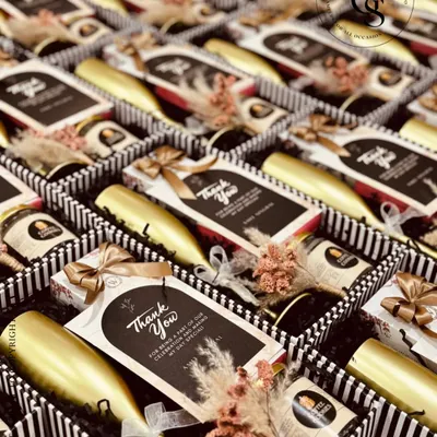 These elegant return gifts are perfect for a sophisticated celebration. The black and white striped boxes contain a miniature bottle and gourmet chocolates, finished with a personalized "Thank You" card, making guests feel truly appreciated.