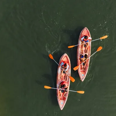 An aerial shot of two kayaks on the calm lake. This is the perfect summer activity to cool off and enjoy the scenery.