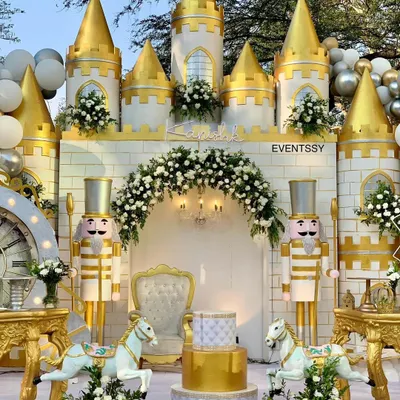 A magnificent royal castle backdrop for a prince's birthday, complete with golden turrets, nutcracker guards, and a floral arch. This setup is designed to be a grand stage for the celebration's main events, including the cake cutting.