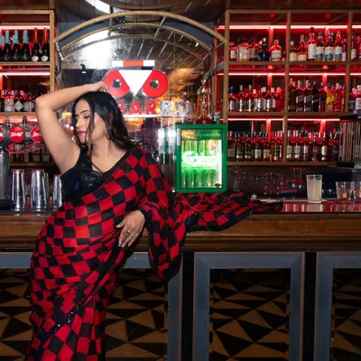 A lifestyle shoot for a fashion influencer at a stylishly lit bar. I use the location's ambiance to create a moody and sophisticated backdrop that complements the modern-ethnic outfit.