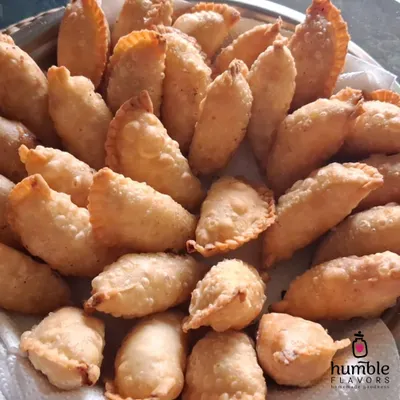 A tray piled high with my signature Mawa Gujiyas, the star sweet of Holi. Each one is handmade with a rich filling of mawa and dry fruits, then fried to golden perfection. It's a taste of tradition that brings so much joy during the festival of colors.