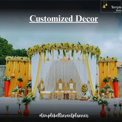 A classic South Indian wedding mandap we designed, showcasing our customized decor services. The setup features traditional yellow and white colors, ornate seating for the couple, and beautiful floral arrangements.