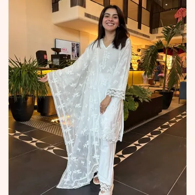 A classic white kurta set is a wardrobe essential. This piece features delicate embroidery and lace details, making it a timeless and elegant choice for any day.