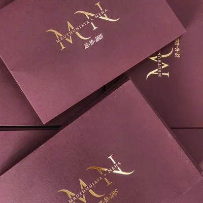 This is the epitome of elegance. A bespoke wedding invitation featuring a portwine envelope with a rich Valentino texture, finished with a luxe gold foil monogram for an unforgettable first impression.
