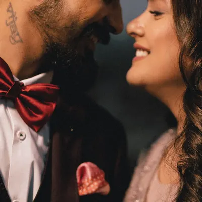 A perfect close-up capturing the joy and intimacy of an engagement. The couple's bright smiles and close embrace, with his stylish red bow tie adding a pop of color, make this a heartwarming portrait.