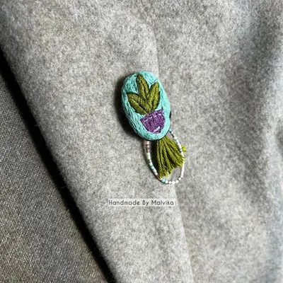 Here is another view of the embroidered plant badge pinned to a coat. I love seeing how a small, handmade accessory can completely change the feel of an outfit, adding a personal and artistic touch.