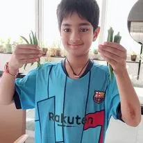 A young gardener proudly displaying his harvest of homegrown beans and okra. Involving children in gardening is a wonderful way to teach them about nature and where their food comes from.