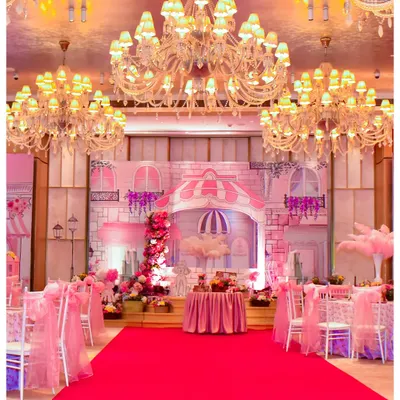 For this Parisian-themed party, I transformed an indoor hall into a romantic street in Paris. The setup includes a grand stage with building facades, a red carpet entrance, and elegant seating under sparkling chandeliers.