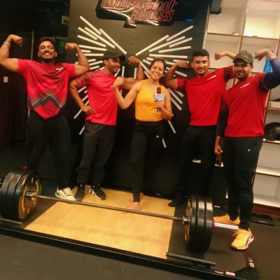 Flexing with the trainers and participants after hosting a fitness challenge at Workout Plus gym. I love the motivating environment of fitness events and enjoy celebrating everyone's hard work and strength.