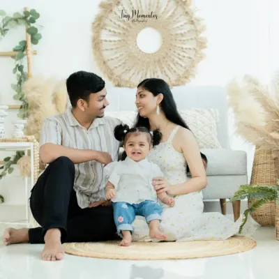 Happiness is being nestled between mom and dad. This full family portrait in my boho setting showcases a beautiful moment of connection, with natural textures adding warmth to the scene.