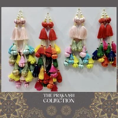 A vibrant collection of multi-layered ethnic tassels, or latkans, in a rainbow of colors. These are ideal for adding a festive and traditional pop to lehenga ties, blouse backs, or dupattas.
