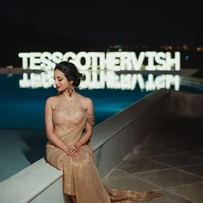 A vision for her reception night. Tessa’s look was pure glamour, with a bold red lip, shimmering gold eyes, and an elegant updo that complemented her stunning Tarun Tahiliani gown.