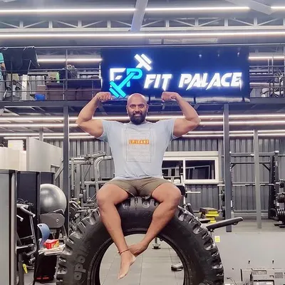 Strength and stillness are two sides of the same coin. Here I am at Fit Palace, taking a moment to flex after a powerful workout session, seated on a tractor tire used for functional training.