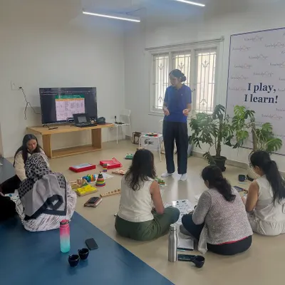A wider view of our early numeracy workshop, showing the informal and collaborative learning environment. With my "I play, I learn!" philosophy as the backdrop, we explore effective strategies for building mathematical foundations.