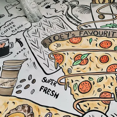 For this pizza cafe's exterior, I illustrated their bestsellers in a quirky doodle style. This section features "Joey's Favourite" pizza, a fun nod for F.R.I.E.N.D.S. fans, with the artwork even wrapping around a pipe.