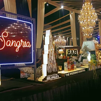 A beautiful and inviting Sangria bar setup. The bright neon sign and elegant decor make it a popular spot for guests to relax and enjoy a refreshing drink.
