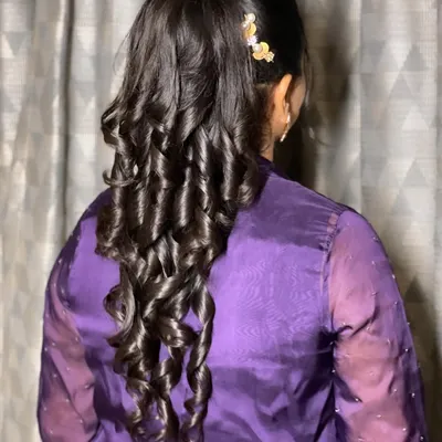 A stunning high ponytail with structured curls. This hairstyle is modern, chic, and keeps the hair off the face, perfect for a party.
