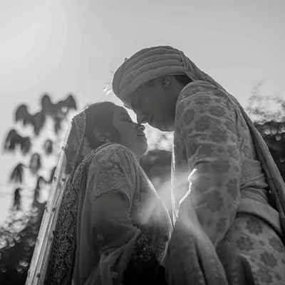 A dramatic black and white silhouette of a couple, backlit by the sun. This technique creates a timeless and romantic portrait, focusing on their connection.