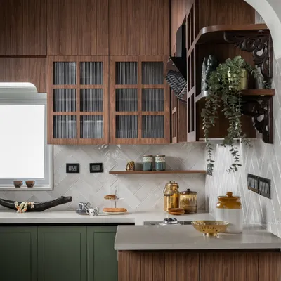 This kitchen proves that functional spaces can also be the most beautiful. I paired rich olive green cabinetry with warm wood tones and fluted glass to create a modern-traditional feel. The gentle archway and carved wooden brackets are details that add a layer of handcrafted charm.