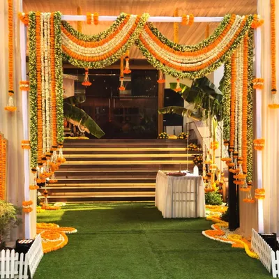 The grand entrance for a Ram-themed thread ceremony at Siddharth Banquets. We used lush garlands of orange and white marigolds to create a traditional and welcoming archway for guests.