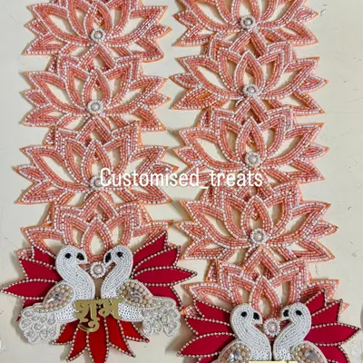 This elegant Shubh Labh set features swan motifs on a base of red leaves, with strings of beaded lotuses. It's a unique design for a modern yet traditional home.