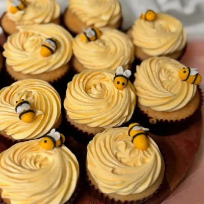 A dozen cupcakes with golden-yellow buttercream rosettes, each topped with a tiny, handcrafted fondant bee. This is a simple yet charming design, perfect for spring events, garden parties, or a 'mom-to-bee' baby shower.
