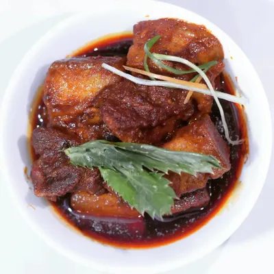 A bowl of my classic pork curry, made with tender chunks of meat in a dark, savory sauce. This dish is a staple and represents the core flavors of my home cooking.