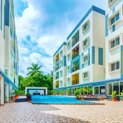 The central courtyard of this apartment complex is designed as a vibrant community hub. The landscape features a swimming pool as the focal point, surrounded by durable paved areas and container plants that add a touch of green to the shared space.