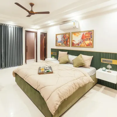 This bedroom in a Jaipur apartment features a custom-fluted green headboard and floating bedside tables. The design combines minimalist forms with rich textures and warm colors to create a cozy yet modern retreat.
