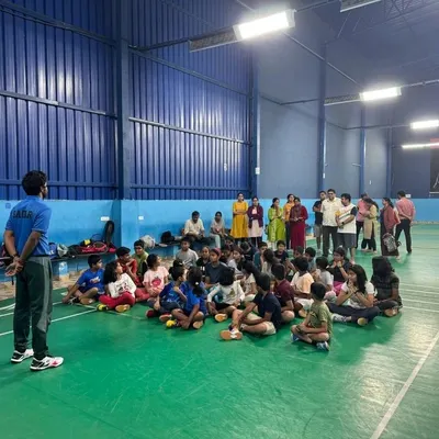 A coach leads a group discussion with our summer camp students. We teach court etiquette and game strategy in addition to physical skills, with parents invited to observe.