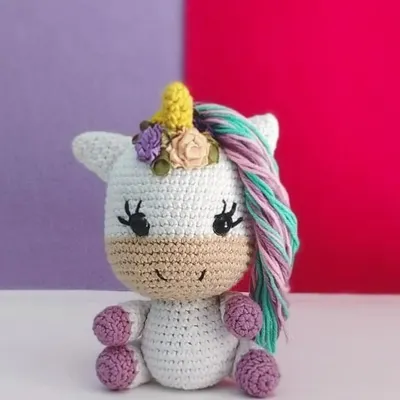 This mini unicorn is ready to spread some magic. I adorned her with a crown of little flowers and gave her a colorful mane with pastel yarn.