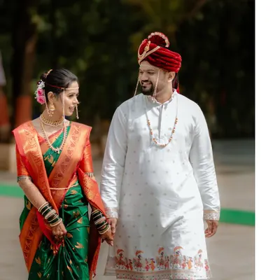 A classic portrait of a Maharashtrian couple on their wedding day, holding hands as they begin their new journey together.