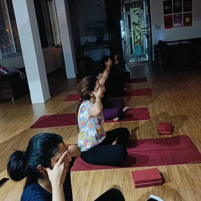 Students practicing a form of pranayama, likely Nadi Shodhana, to calm the nervous system and balance the mind at the start or end of class.