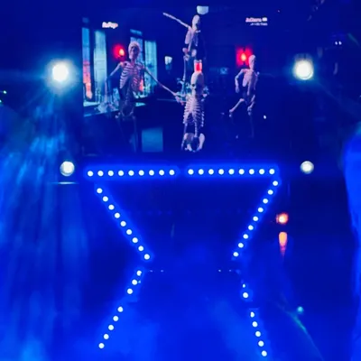 This is my compact DJ setup, perfect for house parties or smaller venues. The package includes sound, a custom X-shaped light truss, and an LED wall, seen here with spooky visuals for a themed party.