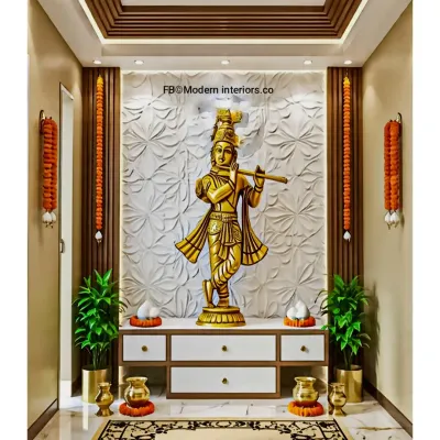 A beautiful pooja unit featuring a large brass Krishna idol against a 3D floral-patterned white backdrop. The unit includes drawers for storage and is framed by wooden slats and traditional marigold garlands.