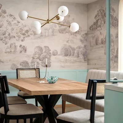 This dining space from the Aqua Home features a stunning custom mural and duck egg blue wainscoting. The mix of a bench and cane-back chairs creates a relaxed yet sophisticated atmosphere, perfect for family meals.