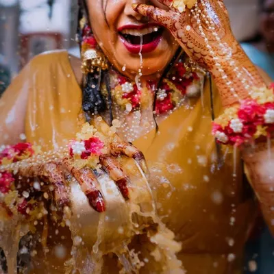 The sheer joy of a bride during her Haldi ceremony, captured in a moment of playful celebration. We love the energy and vibrant colors of these events.